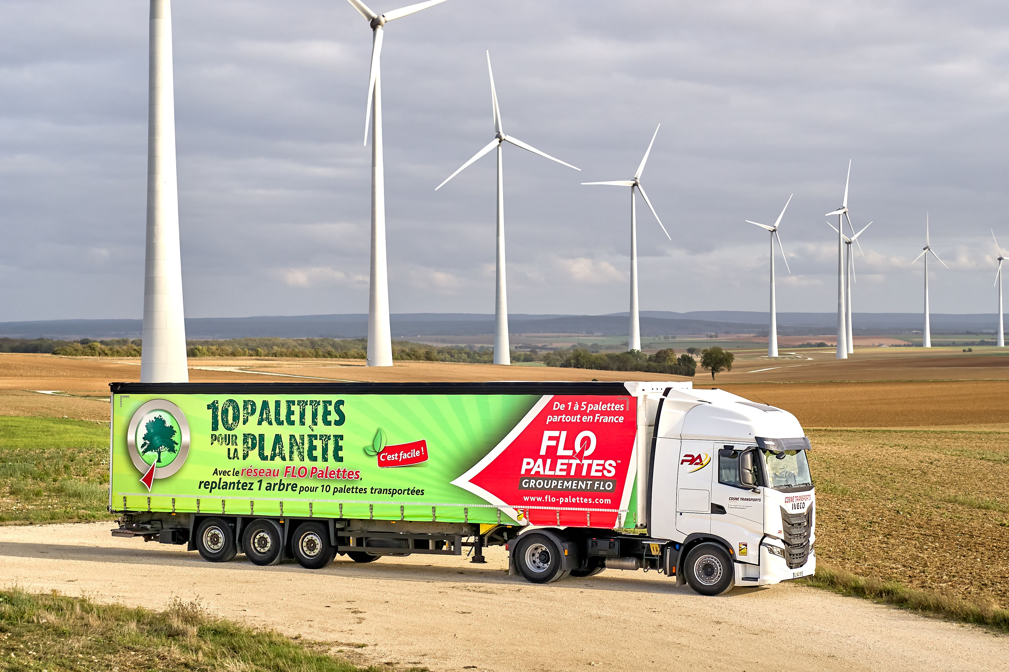 Image d'un camion à côter d'éolienne